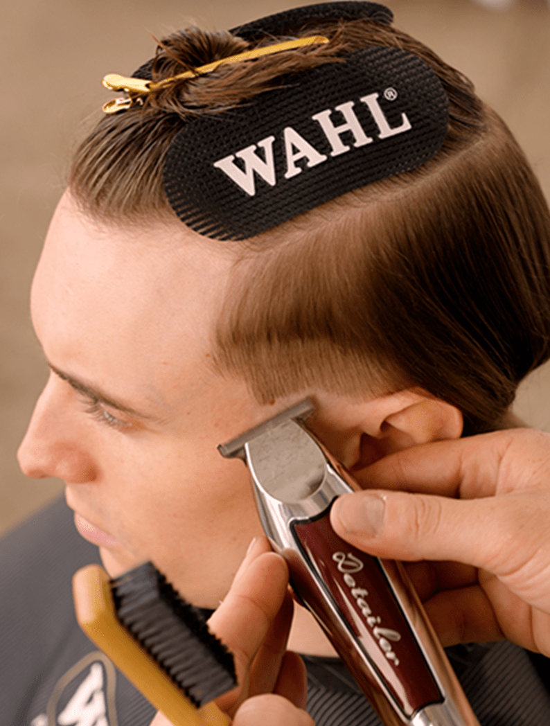 Barber using Wahl Detailer Li to cut lines into a model's hair